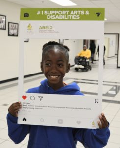 Young elementary school girl poses with selfie image picture frame for at the Disability Awareness Career Day.