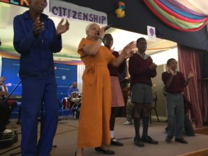 SHOWAbility Executive Director Myrna Clayton singing on stage with talented young men on the disability spectrum at a school for disabled students in Namibia south west Africa.