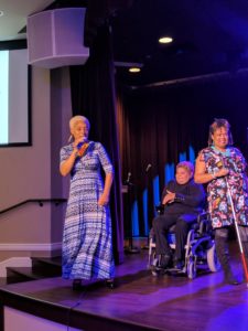 SHOWAbility Executive Director Myrna Clayton sings as fashion models on the disability spectrum showcase their fashions.