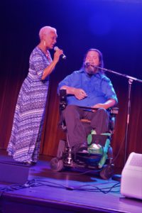 SHOWAbility Executive Director Myrna Clayton sings duet with wheelchair user, Rusty Taylor.
